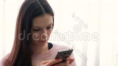 年轻的黑发女人<strong>正在</strong>手机上<strong>输入</strong>一条信息，看着屏幕。